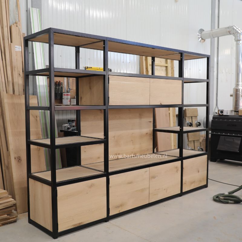 Een maatwerk kast van eikenhout en staal voor de bedrijfsruimte uit meerdere delen